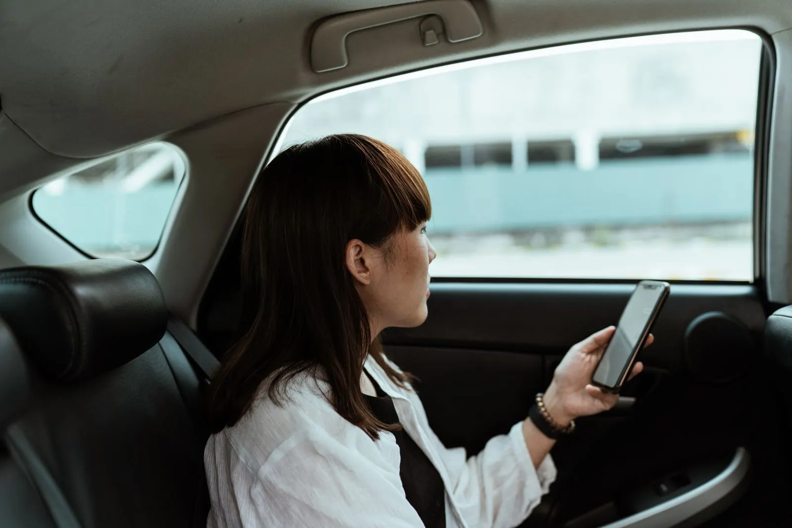 Rider using her phone in a cab backseat
