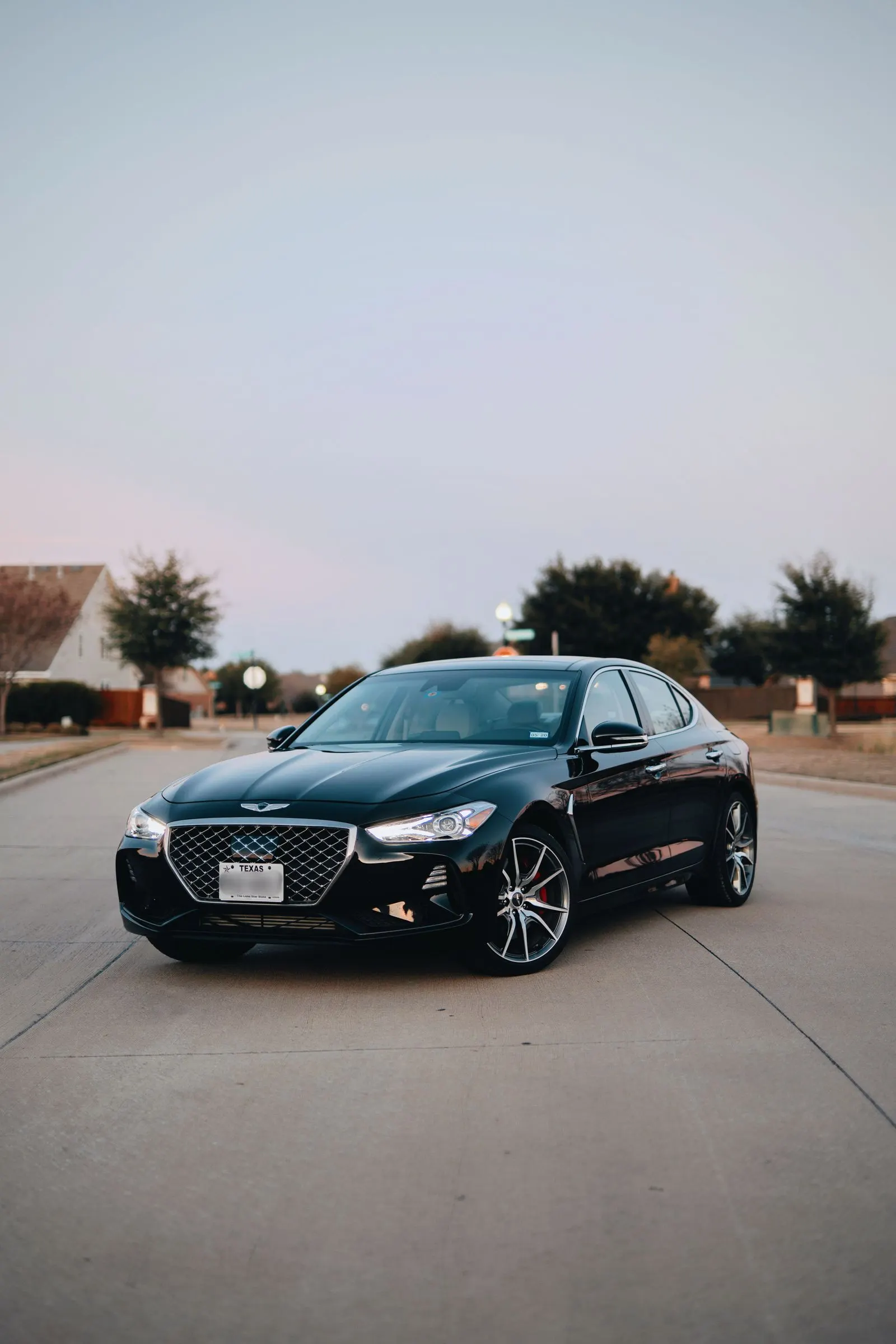 Black sedan with headlights on