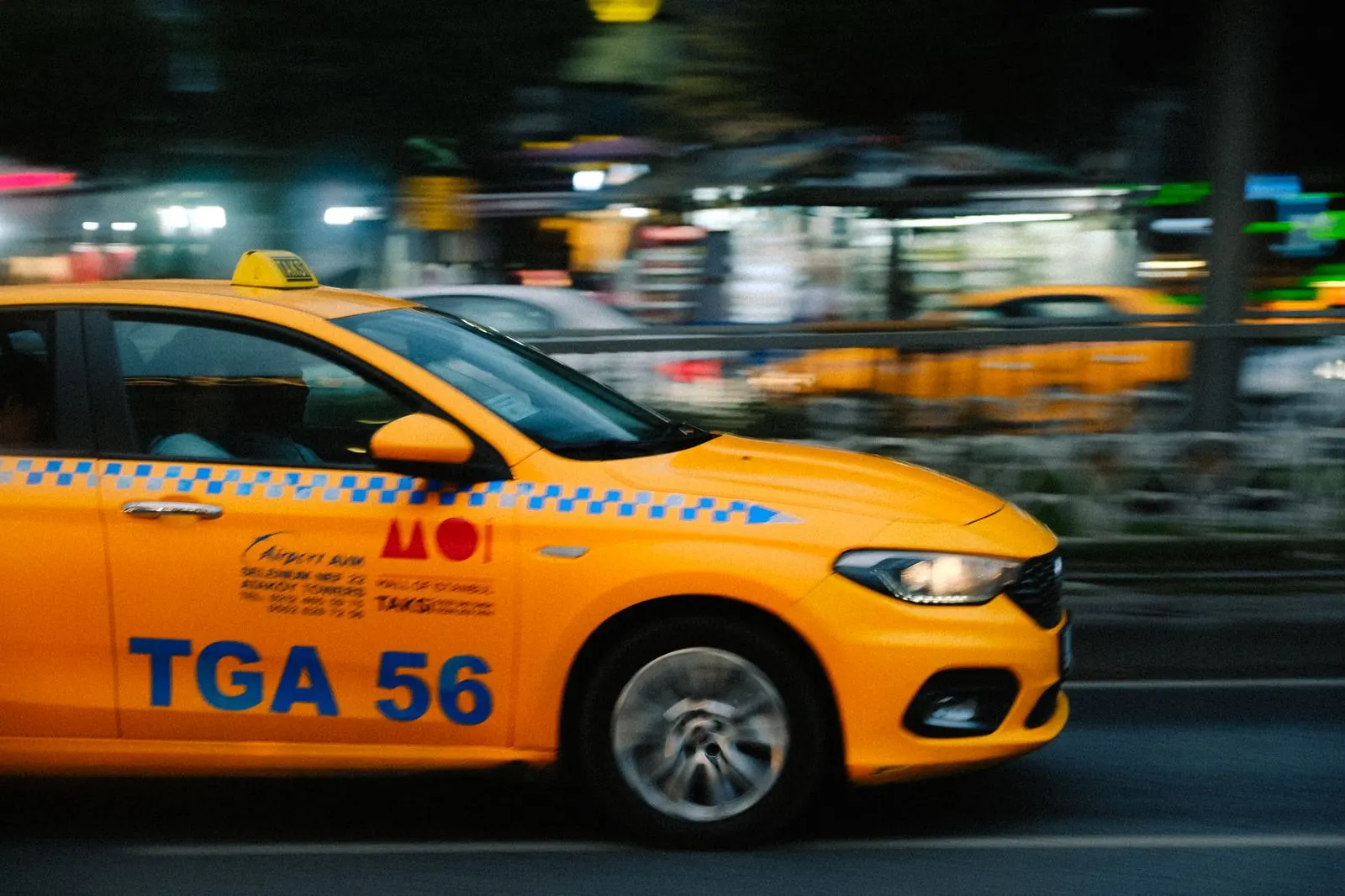 Taxi crossing a city street at night